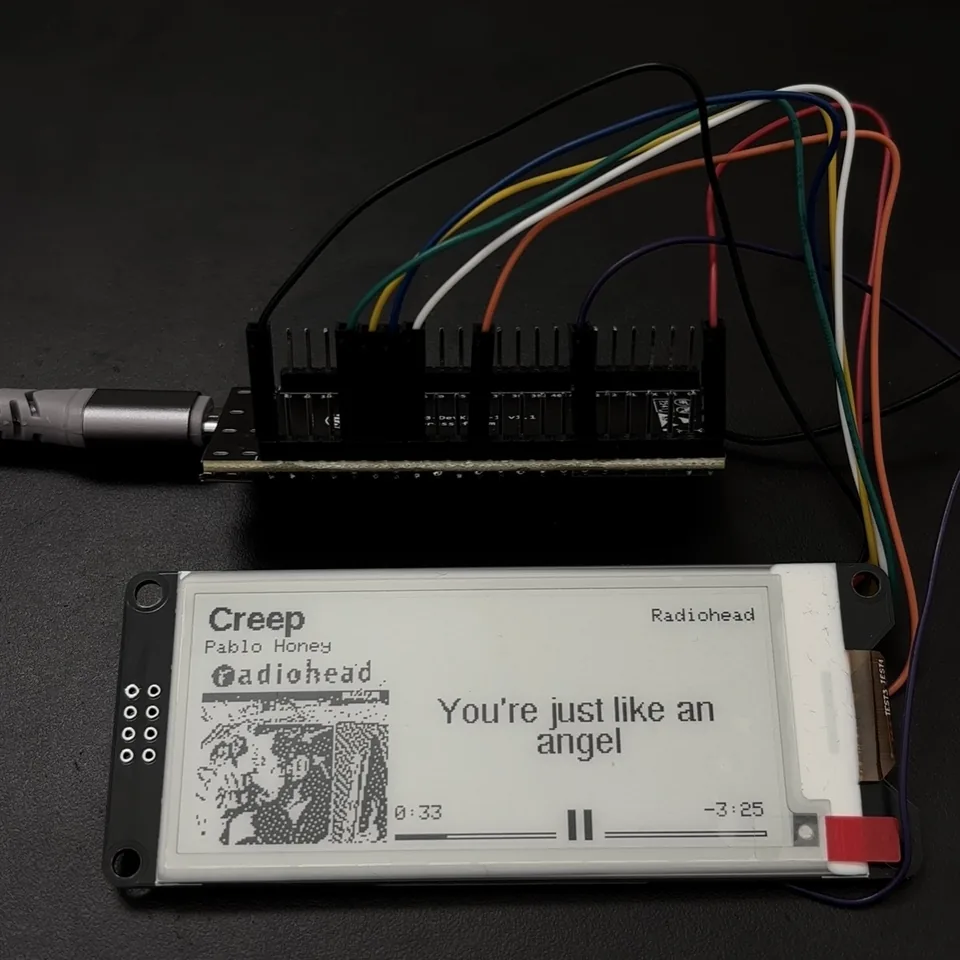 MusicStation v1 prototype showing Radiohead album artwork, synchronized lyrics, playback time, and pause state on a monochrome e-paper display