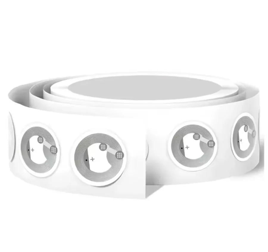 A roll of round white NTAG215 NFC stickers with the antenna coil and chip visible through the label